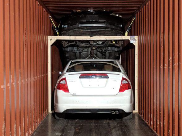 Multiple cars in shipping container.